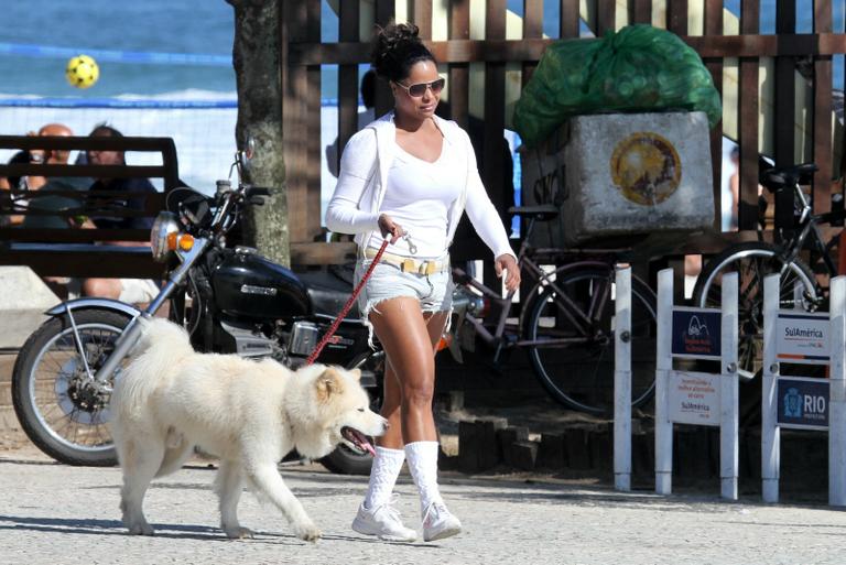 Adriana Bombom passeia com seu akita na orla da Barra da Tijuca