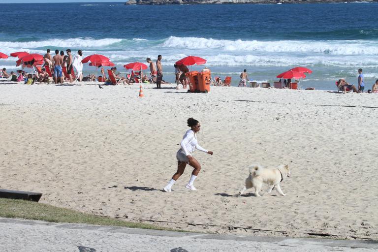 Adriana Bombom passeia com seu akita na orla da Barra da Tijuca