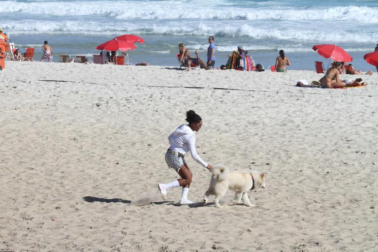 Adriana Bombom passeia com seu akita na orla da Barra da Tijuca