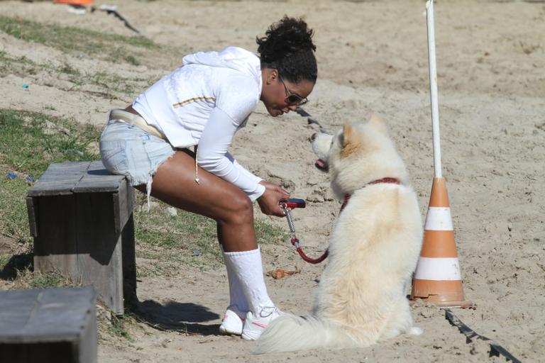 Adriana Bombom passeia com seu akita na orla da Barra da Tijuca