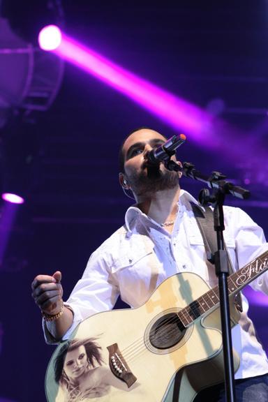 Luciano toca violão com foto da esposa