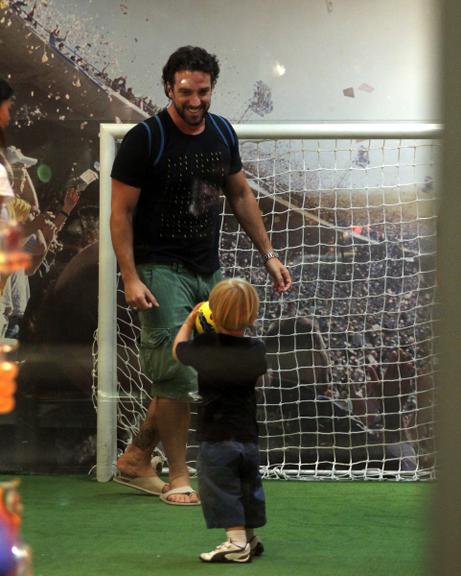 Carlos Bonow brinca com o filho em shopping no Rio de Janeiro