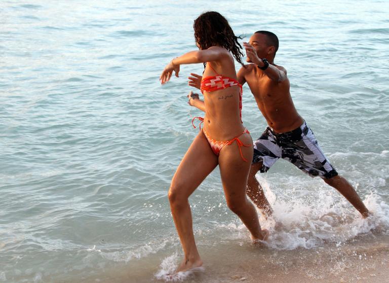 Rihanna brinca no mar, em Barbados, com seu irmão mais novo