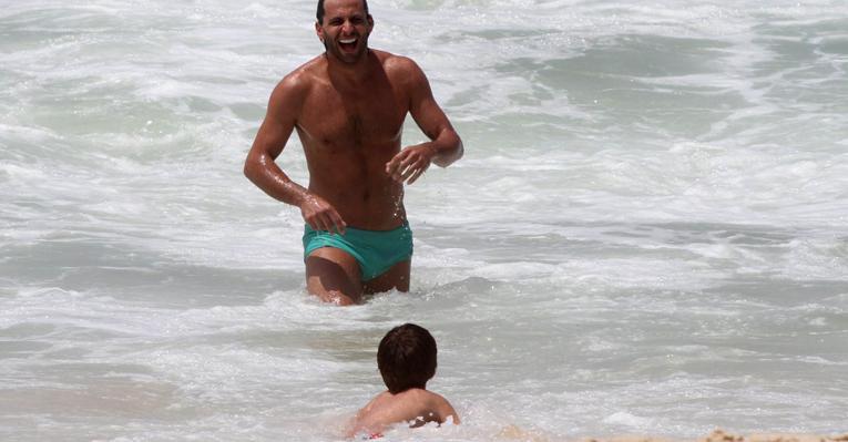 Henri Castelli brinca com o filho, Lucas, na praia