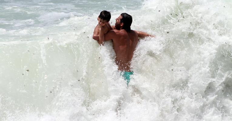 Henri Castelli brinca com o filho, Lucas, na praia