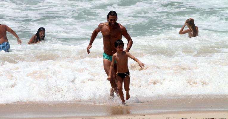 Henri Castelli brinca com o filho, Lucas, na praia