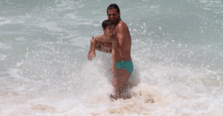 Henri Castelli brinca com o filho, Lucas, na praia