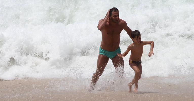 Henri Castelli brinca com o filho, Lucas, na praia