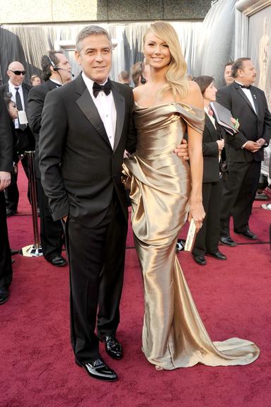 George Clooney, de Armani, e a namorada, Stacy Keibler, com look metálico Marchesaada, Stacy Klieber, com look metálico Marquesa