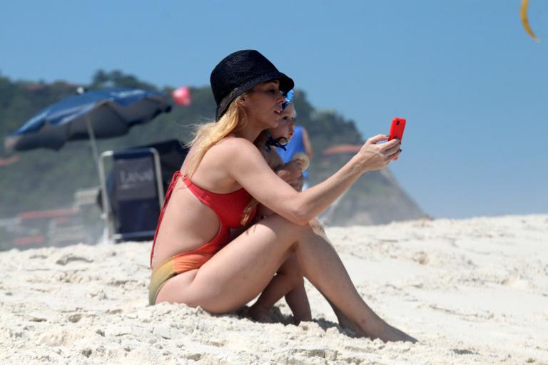 Danielle Winits brinca com seu caçula Guy em praia carioca