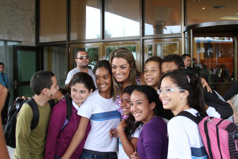 Monique posa com fãs em frente ao hotel