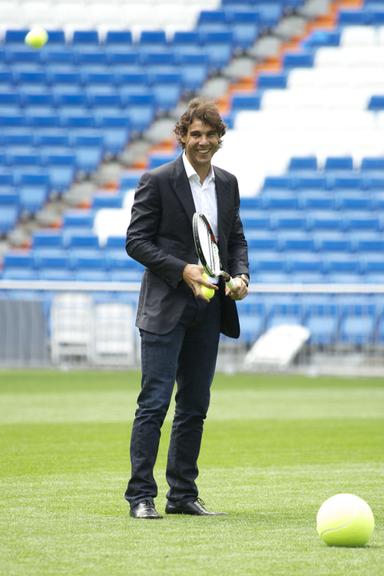 De terno e sapato, Rafael Nadal joga tênis no campo do Real Madrid