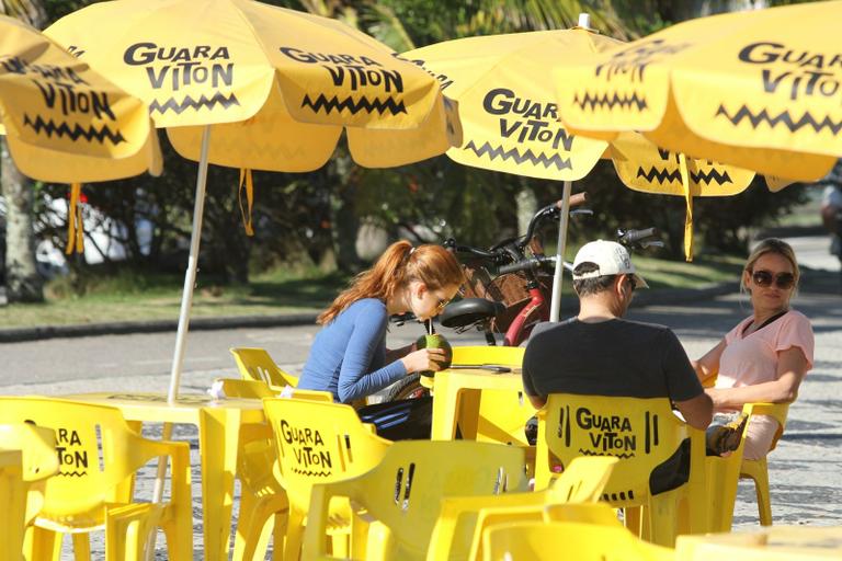 Marina Ruy Barbosa bebe água de coco na Barra da Tijuca, no Rio