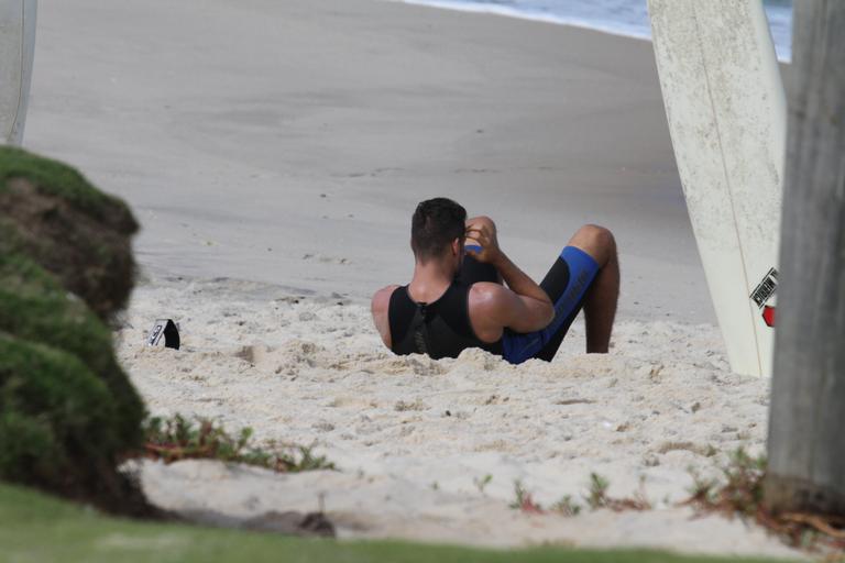 Cauã Reymond se alonga antes do surfe