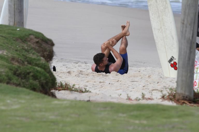 Cauã Reymond se alonga antes do surfe