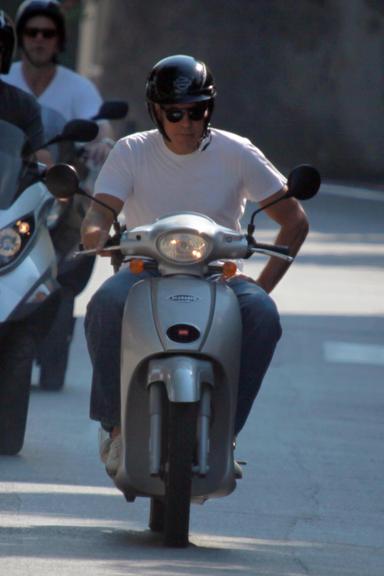 George Clooney passeia de scooter com amigos pela Itália