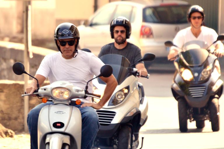 George Clooney passeia de scooter com amigos pela Itália