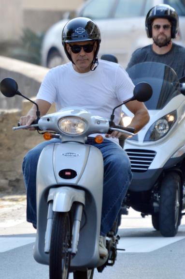 George Clooney passeia de scooter com amigos pela Itália