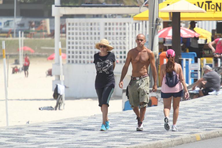 Betty Lago caminha na praia do Leblon com o filho