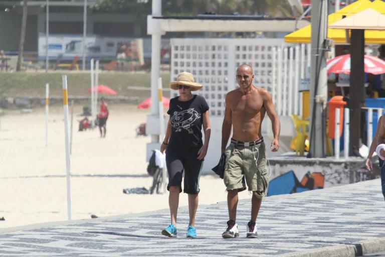 Betty Lago caminha na praia do Leblon com o filho