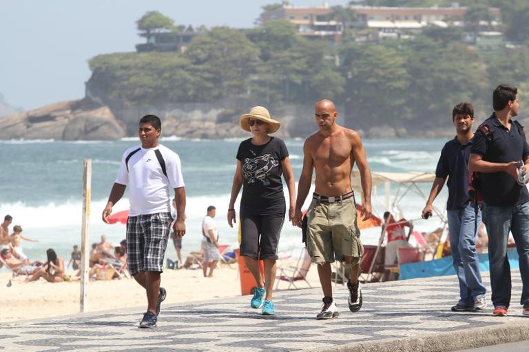 Betty Lago caminha na praia do Leblon com o filho