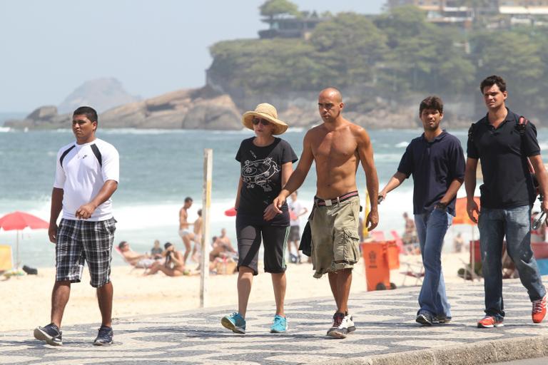 Betty Lago caminha na praia do Leblon com o filho