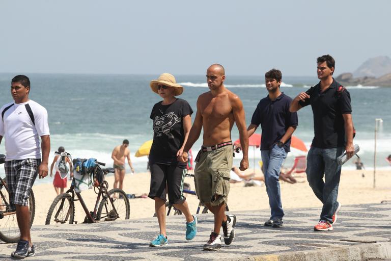 Betty Lago caminha na praia do Leblon com o filho