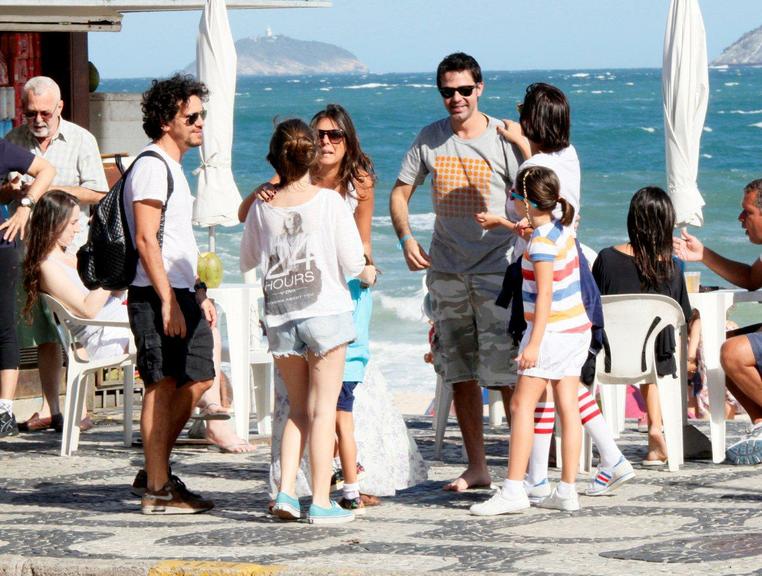 Bruno Mazzeo, com novo visual, e namorada na praia do Leblon