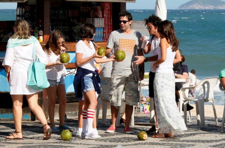 Bruno Mazzeo, com novo visual, e namorada na praia do Leblon