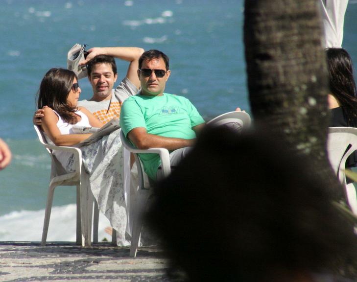 Bruno Mazzeo, com novo visual, e namorada na praia do Leblon