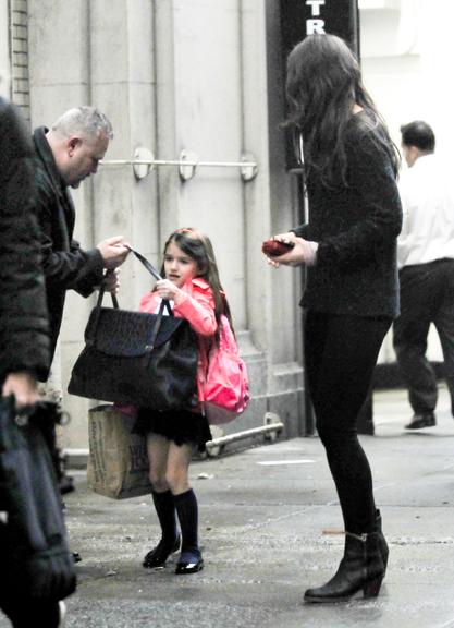 Suri Cruise exibe seu uniforme escolar em passeio com a mãe