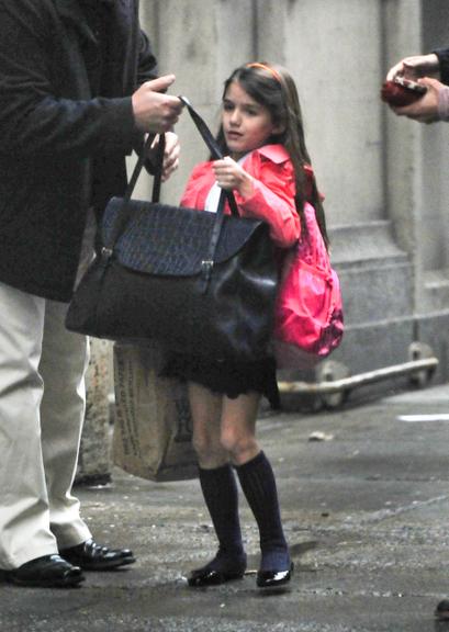 Suri Cruise exibe seu uniforme escolar em passeio com a mãe