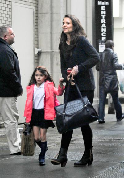 Suri Cruise exibe seu uniforme escolar em passeio com a mãe