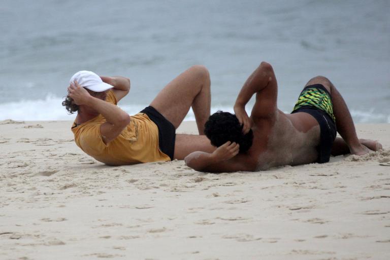 Marcello Novaes se exercita com o filho Diogo, na praia da Barra