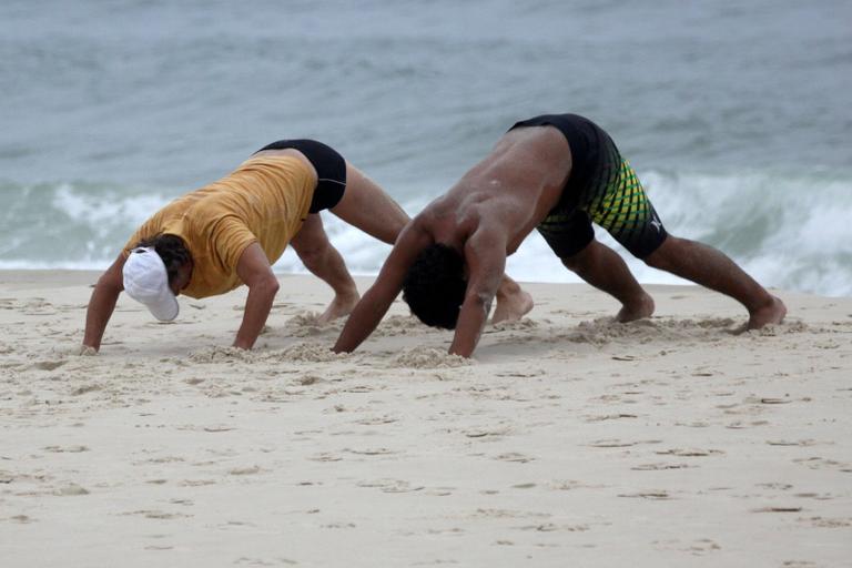 Marcello Novaes se exercita com o filho Diogo, na praia da Barra