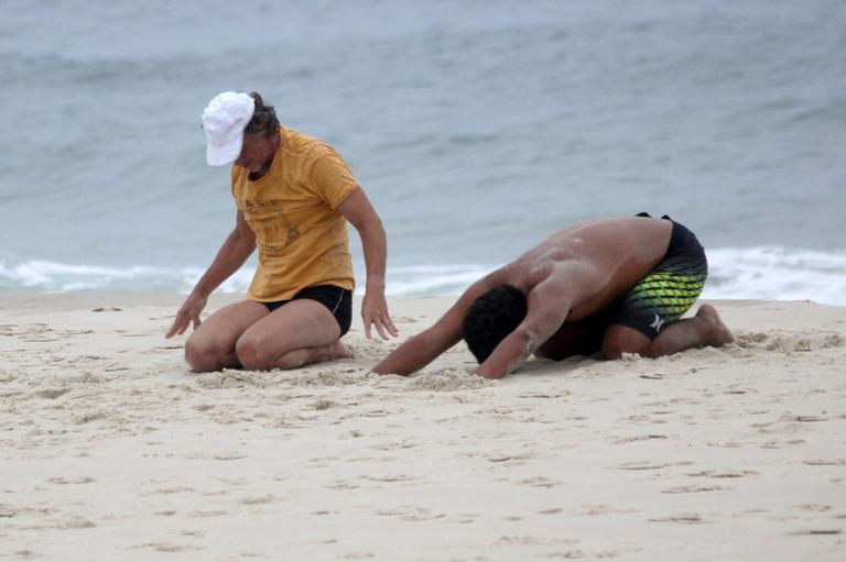 Marcello Novaes se exercita com o filho Diogo, na praia da Barra