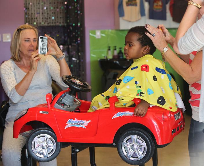 Filho de Charlize Theron corta cabelo em cima de carrinho