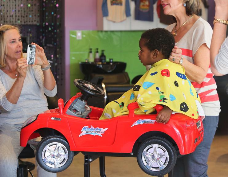 Filho de Charlize Theron corta cabelo em cima de carrinho