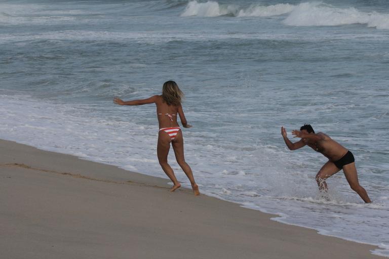 Flávia Alessandra e Rodrigo Lombardi gravam cenas de amor na praia