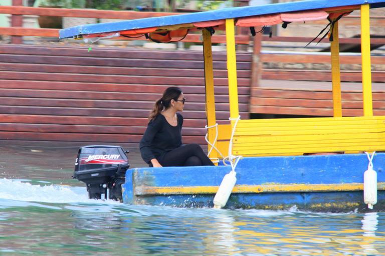 Dira Paes pilota barco ao sair de ilha 