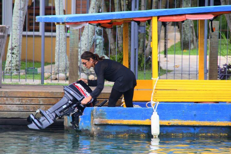 Dira Paes pilota barco ao sair de ilha 