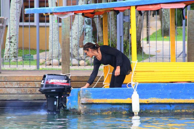 Dira Paes pilota barco ao sair de ilha 