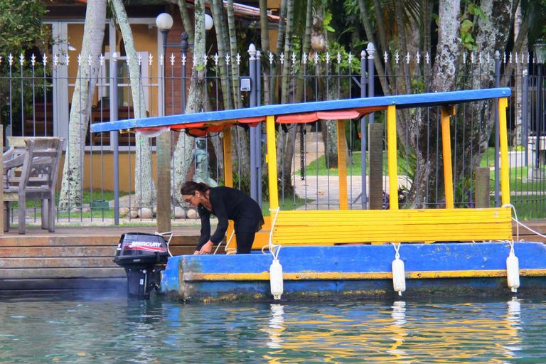 Dira Paes pilota barco ao sair de ilha 