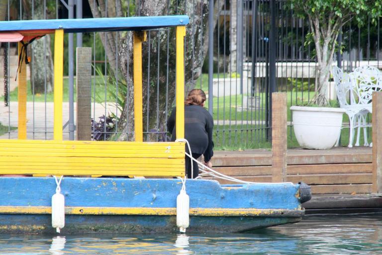 Dira Paes pilota barco ao sair de ilha 