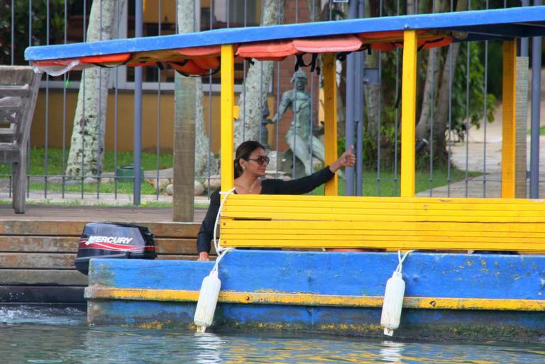 Dira Paes pilota barco ao sair de ilha 