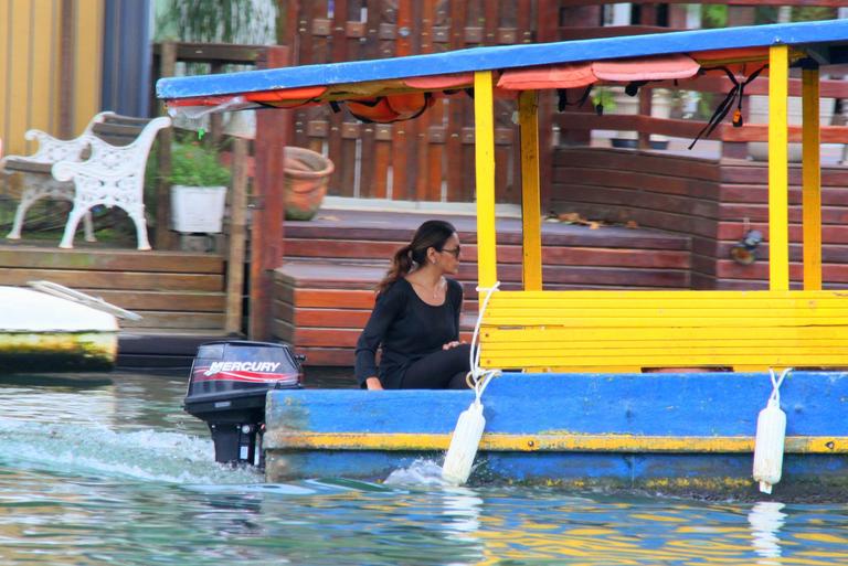 Dira Paes pilota barco ao sair de ilha 