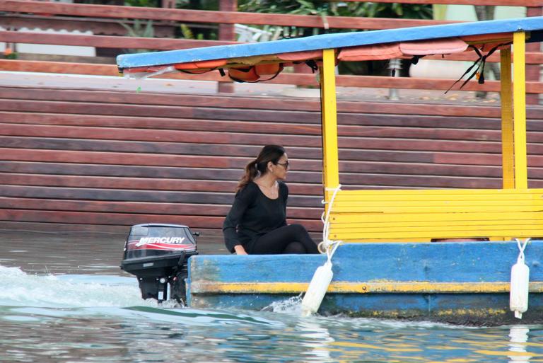 Dira Paes pilota barco ao sair de ilha 