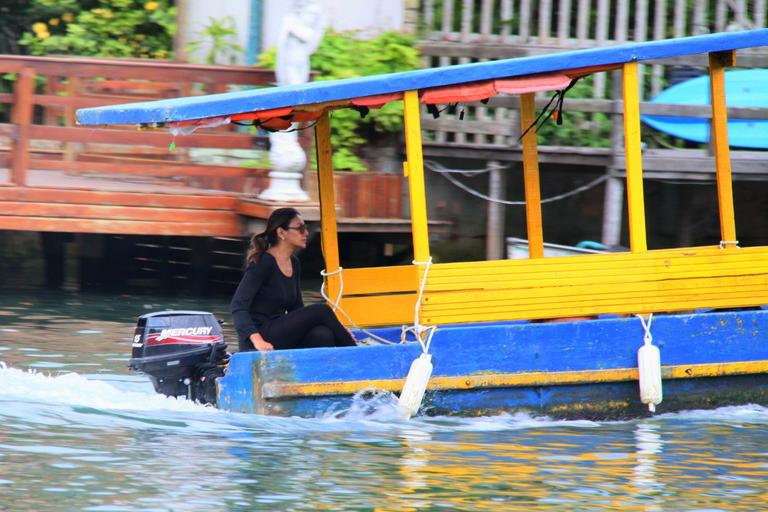 Dira Paes pilota barco ao sair de ilha 