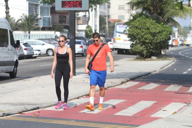 Enzo Celulari corre com a namorada em orla da praia no Rio