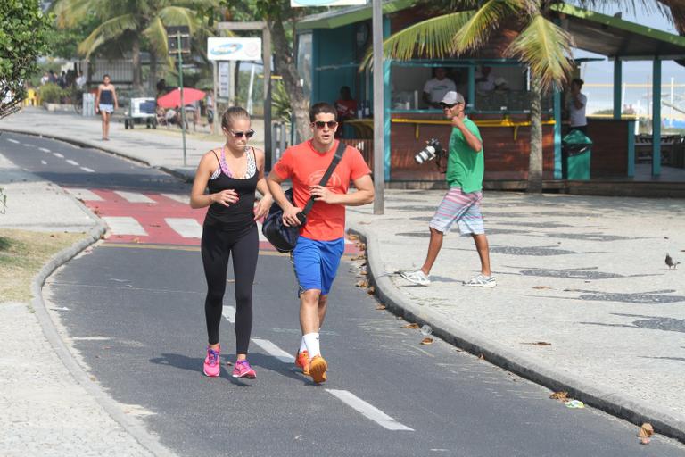 Enzo Celulari corre com a namorada em orla da praia no Rio